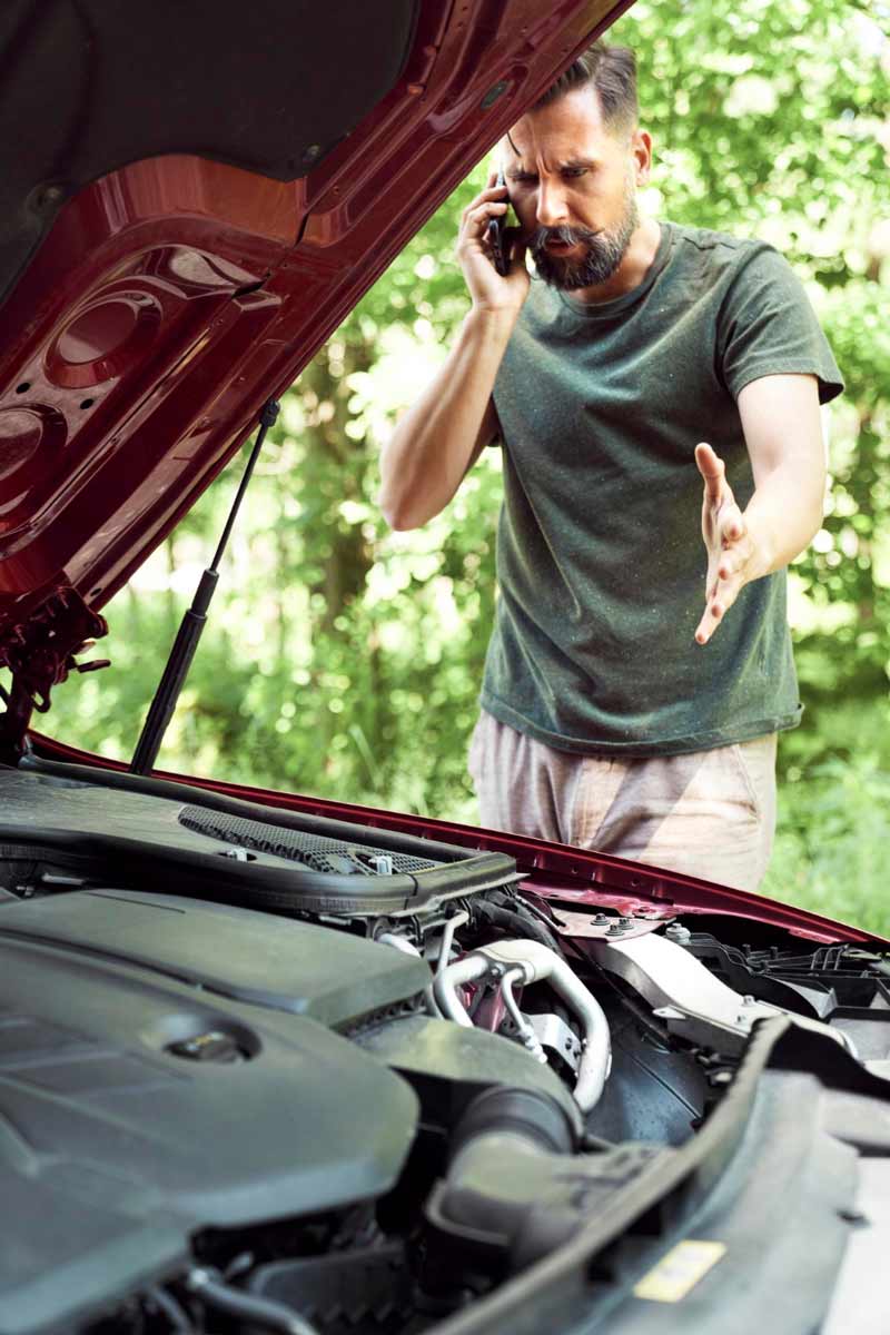 Junger Mann prüft Getriebeschaden bei Schrottauto Ankauf Osnabrück